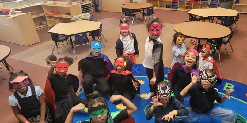 Group of MMA students pose for a picture in the classroom dressed as superheroes for NWEA testing.