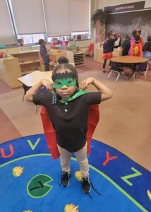 MMA student dressed as a superhero flexes for a picture on NWEA test day.