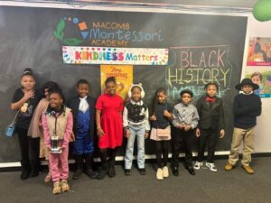 Maxomb Montessori Academy students pose in front of the whiteboard in the classroom to celebrate spirit week for Black History Month